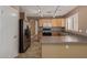 Bright kitchen featuring track lighting, tile floors, stainless steel refrigerator and light wood cabinetry at 5336 W Campo Bello Dr, Glendale, AZ 85308