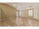 Well-lit living room featuring tiled floors, plantation shutters, and a ceiling fan at 5336 W Campo Bello Dr, Glendale, AZ 85308