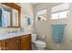 A bright bathroom features a wood vanity with marble countertop and two windows at 5415 E Mckellips Rd # 100, Mesa, AZ 85215