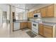 Well-lit kitchen featuring wooden cabinets and white appliances at 5415 E Mckellips Rd # 100, Mesa, AZ 85215