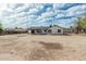 View of a large dirt backyard and the home's exterior with a covered patio area at 6701 W Monterey Way, Phoenix, AZ 85033