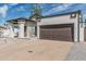 Single-story home featuring a large two-car garage, white stucco and brown trim exterior at 6701 W Monterey Way, Phoenix, AZ 85033
