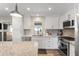 Updated kitchen showcasing white cabinetry, quartz countertops, stainless steel appliances, and stylish backsplash at 7320 E Pierce St, Scottsdale, AZ 85257