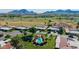 Scenic aerial view of a well-maintained property with a pool, lush landscaping, and a nearby golf course at 7615 E Tucson Rd, Scottsdale, AZ 85258