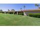 Well-maintained backyard with lush green grass, mature landscaping, and a charming covered patio area at 7615 E Tucson Rd, Scottsdale, AZ 85258