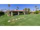 Well-maintained backyard with lush green grass, mature landscaping, and a charming covered patio area at 7615 E Tucson Rd, Scottsdale, AZ 85258
