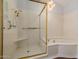 Bright bathroom features an enclosed shower with gold hardware, a jacuzzi tub, and updated lighting at 7615 E Tucson Rd, Scottsdale, AZ 85258