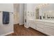 Bright bathroom showcases a dual sink vanity with plenty of cabinet space, a large mirror, and wood look floors at 7615 E Tucson Rd, Scottsdale, AZ 85258