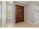 Welcoming entryway featuring tile flooring and a carved wood front door with sidelight at 7615 E Tucson Rd, Scottsdale, AZ 85258