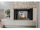 Cozy fireplace featuring stone surround, tiled hearth and rustic mantel in a well lit living room at 7615 E Tucson Rd, Scottsdale, AZ 85258