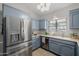 Well-equipped kitchen featuring stainless steel refrigerator and blue cabinets at 7615 E Tucson Rd, Scottsdale, AZ 85258