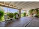 This covered patio offers a relaxing space with lush greenery, concrete flooring, and comfortable seating at 7615 E Tucson Rd, Scottsdale, AZ 85258
