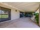 This covered patio offers a relaxing space with lush greenery, concrete flooring, and comfortable seating at 7615 E Tucson Rd, Scottsdale, AZ 85258