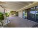 This covered patio offers a relaxing space with lush greenery, concrete flooring, and comfortable seating at 7615 E Tucson Rd, Scottsdale, AZ 85258