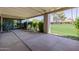 This covered patio offers a relaxing space with lush greenery, concrete flooring, and comfortable seating at 7615 E Tucson Rd, Scottsdale, AZ 85258