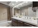 Well-lit bathroom showcasing a modern vanity, large mirror, and a shower-tub combination at 7714 N 17Th Pl, Phoenix, AZ 85020