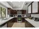 Well lit kitchen featuring stainless steel appliances, white countertops, and dark wood cabinetry at 7714 N 17Th Pl, Phoenix, AZ 85020