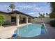 Backyard pool with a covered patio, desert landscaping, palm trees, and a clear blue sky at 7714 N 17Th Pl, Phoenix, AZ 85020
