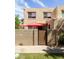 Inviting condo facade with a private patio featuring a stylish wood gate and red patio umbrellas at 8061 E Glenrosa Ave, Scottsdale, AZ 85251