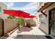 Private patio featuring red patio umbrellas, a security gate, and desert landscaping at 8061 E Glenrosa Ave, Scottsdale, AZ 85251