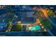 Night aerial view of backyard showing the green pool with lights and covered patio at 8502 E Malcomb Dr, Scottsdale, AZ 85250