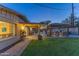 Scenic backyard offers a pool, a covered patio with bar, a built-in barbecue grill, and a well-manicured lawn at 8502 E Malcomb Dr, Scottsdale, AZ 85250