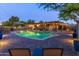A lush backyard with a pool, a covered patio with bar and barbecue, and brick pavers throughout at 8502 E Malcomb Dr, Scottsdale, AZ 85250