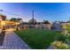 Beautiful backyard featuring lush lawn, a covered patio with bar, and a built-in barbecue and a pool at 8502 E Malcomb Dr, Scottsdale, AZ 85250