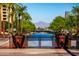 View of walking bridge with green trees and plants and a mountain in the background at 8502 E Malcomb Dr, Scottsdale, AZ 85250