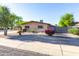 A charming home's exterior with desert landscaping, mature trees, and vibrant flowering bushes at 8502 E Malcomb Dr, Scottsdale, AZ 85250