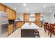 Bright, spacious kitchen with stainless steel appliances, quartz counters, wood cabinets, and island with barstool seating at 8502 E Malcomb Dr, Scottsdale, AZ 85250