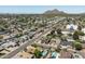 Expansive aerial shot of a neighborhood, showcasing lush greenery and mountain views at 8502 E Rose Ln, Scottsdale, AZ 85250