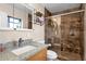 Bathroom featuring a granite countertop vanity, a tiled shower with a glass door, and ample lighting at 8644 E Roanoke Ave, Scottsdale, AZ 85257