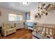 Bright Bedroom with hardwood floors, a crib, a changing table, and a comfortable recliner, perfect for a new Gathering at 8644 E Roanoke Ave, Scottsdale, AZ 85257