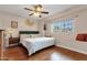 Comfortable bedroom featuring hardwood floors, a ceiling fan, and a window seat, providing a cozy and inviting atmosphere at 8644 E Roanoke Ave, Scottsdale, AZ 85257