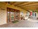 A covered patio features brick pavers, outdoor furniture, and french doors at 8644 E Roanoke Ave, Scottsdale, AZ 85257
