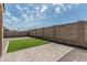 Enclosed backyard featuring artificial turf, a brick paver patio, and a block wall at 8715 W Agora Ln, Tolleson, AZ 85353