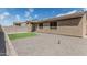 Backyard featuring artificial turf, rock landscaping, and a house with dark window frames at 8715 W Agora Ln, Tolleson, AZ 85353