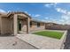 Backyard showcasing the home's facade, a patio area, and low maintenance landscaping at 8715 W Agora Ln, Tolleson, AZ 85353
