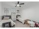 Cozy bedroom featuring twin beds, neutral decor, and a ceiling fan for a comfortable space at 8715 W Agora Ln, Tolleson, AZ 85353