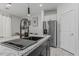 Modern kitchen with granite countertops, a sleek sink, stainless steel refrigerator, and white cabinetry at 8715 W Agora Ln, Tolleson, AZ 85353