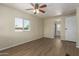 Well-lit bedroom features wood-look floors, a ceiling fan, and a large window at 9710 E Baywood Ave, Mesa, AZ 85208