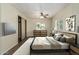 Well-lit bedroom features modern decor, wood-look floors, and a ceiling fan at 9710 E Baywood Ave, Mesa, AZ 85208