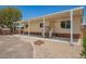 Quaint home with a covered front porch, features landscaped gravel yard, and desert surroundings, perfect for relaxation at 9710 E Baywood Ave, Mesa, AZ 85208