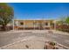 Charming single-story home featuring a covered porch, desert landscaping, and a gravel driveway under a clear blue sky at 9710 E Baywood Ave, Mesa, AZ 85208