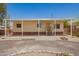 Single-story home featuring a covered porch, desert landscaping, and a gravel driveway under a clear blue sky at 9710 E Baywood Ave, Mesa, AZ 85208