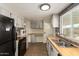 Updated kitchen with gray cabinets, butcher block counters, black appliances, and gray backsplash at 9710 E Baywood Ave, Mesa, AZ 85208