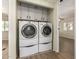 A convenient laundry area with a side-by-side washer and dryer and upper cabinets for storage at 9710 E Baywood Ave, Mesa, AZ 85208