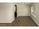 Open living room with wood-look floors, neutral paint, and an opening to the kitchen at 9710 E Baywood Ave, Mesa, AZ 85208