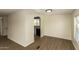 Open living room featuring wood-look floors, neutral paint, and access to the kitchen at 9710 E Baywood Ave, Mesa, AZ 85208